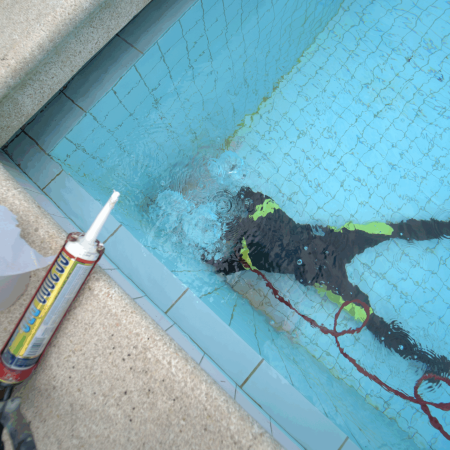 Plongeur réparant une piscine sous l'eau.